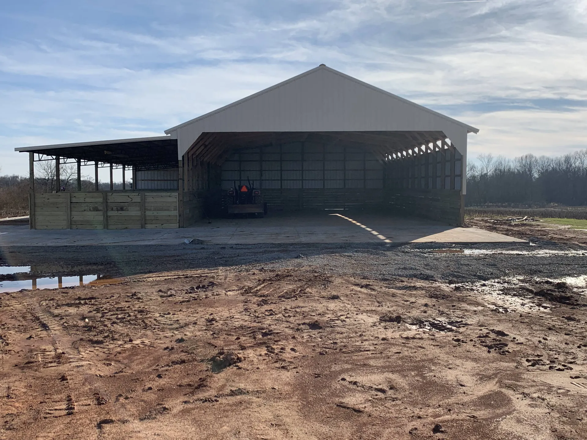 A large metal agricultural building with side lean-tos
