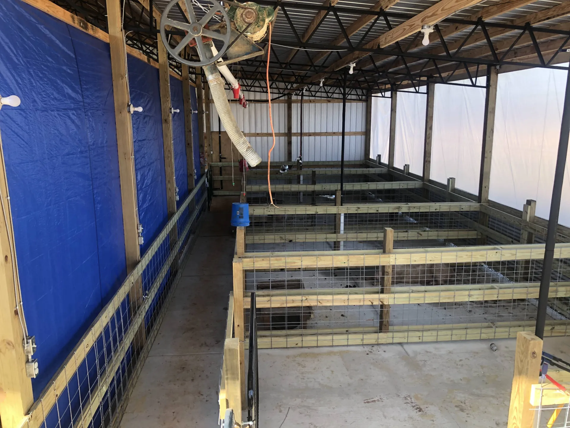 The inside of a poultry house under construction with blue curtain walls