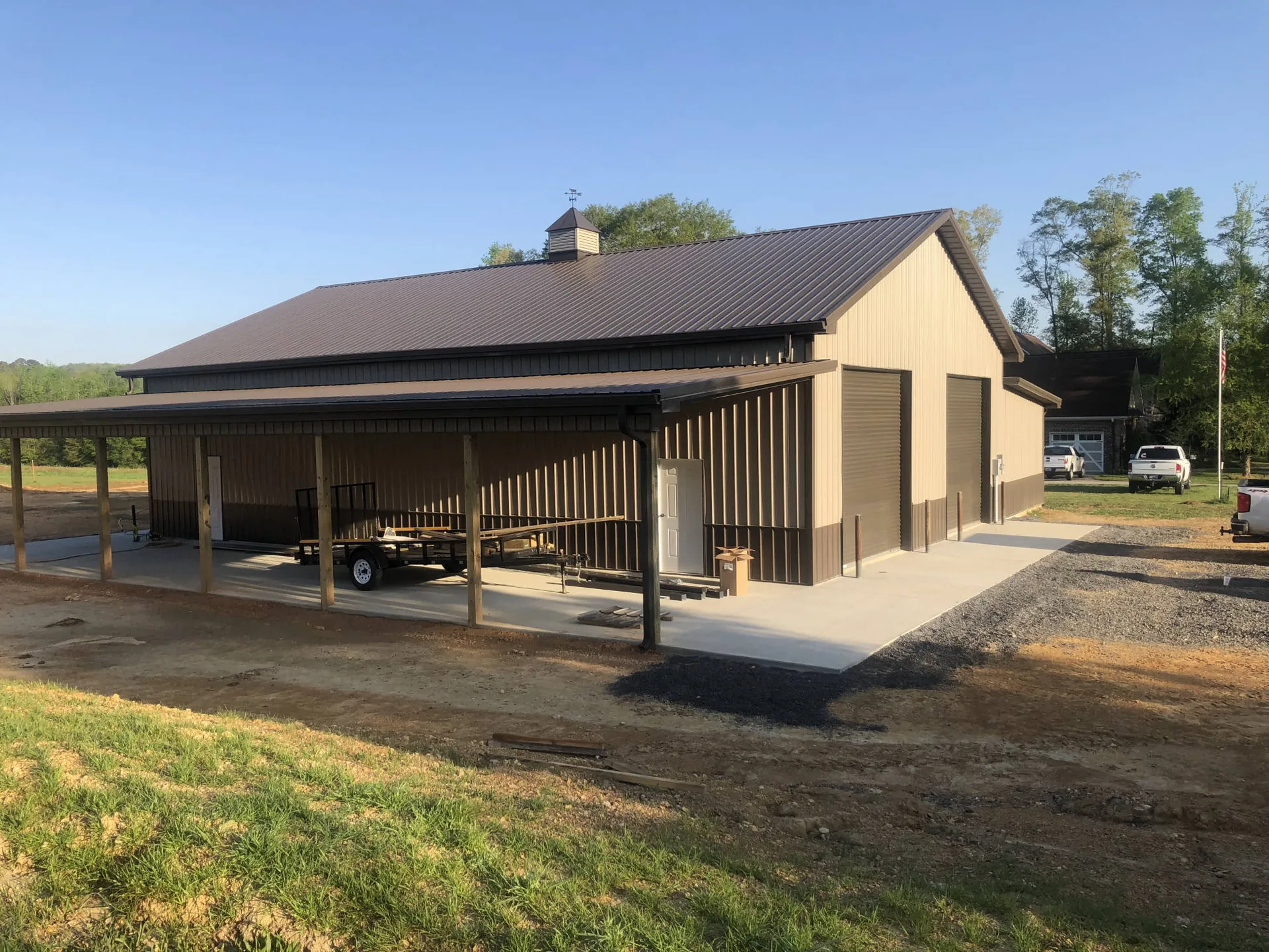 A metal building with a dark roof and an attached carport