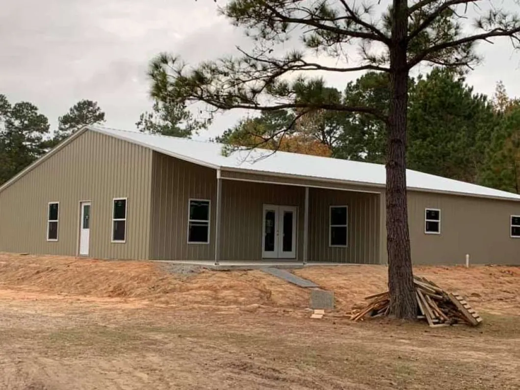 A tan barndominium with a metal roof under construction