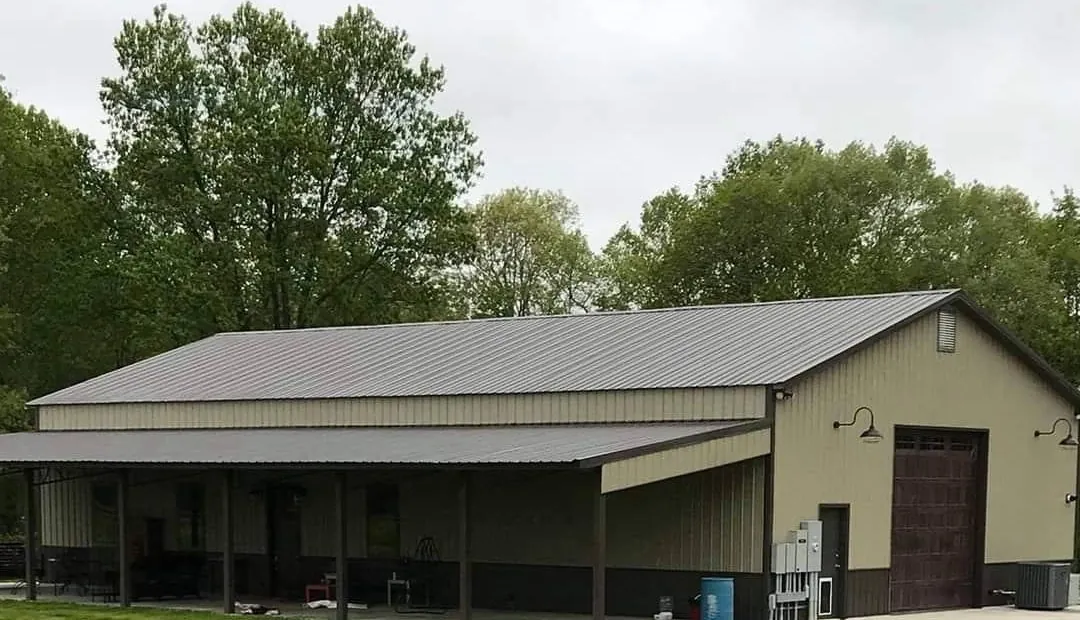 A tan metal building with a gray metal roof